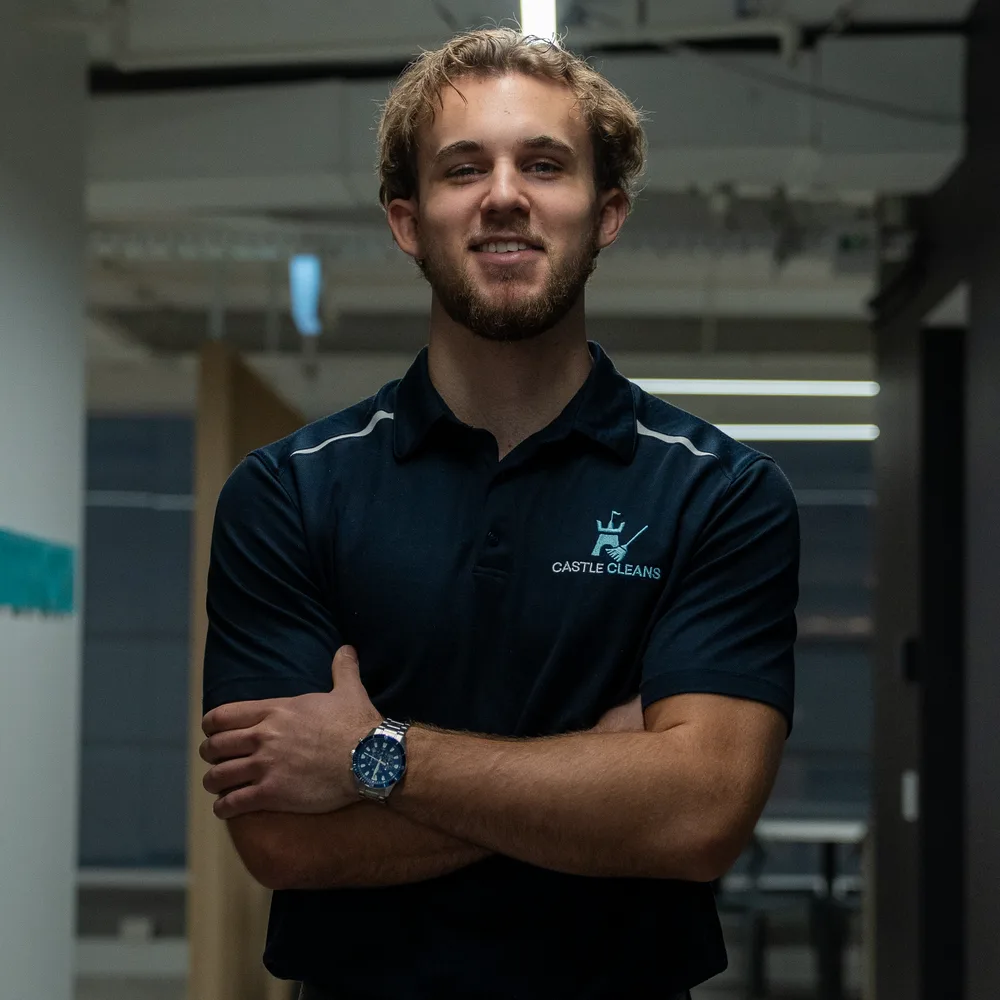 Ryan Castle, director of Castle Cleans, standing in a Sydney office in branded uniform